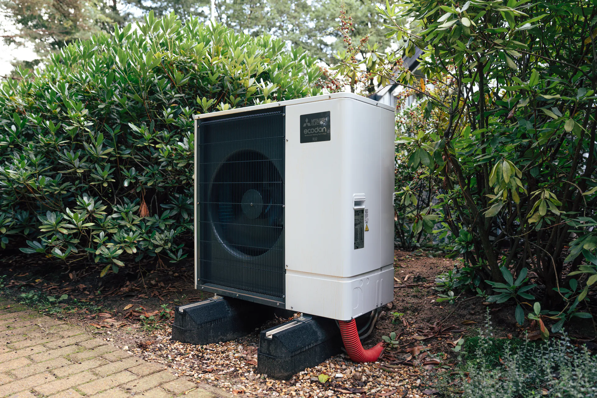 Buitenunit van een warmtepomp in de tuin
